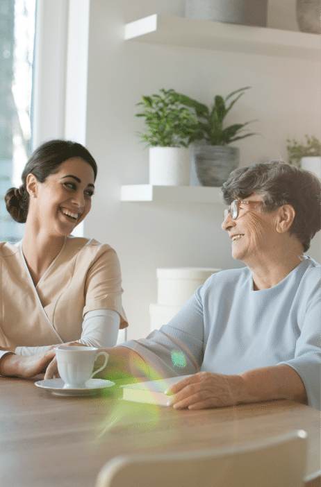 nurse and woman at table smiling and talking